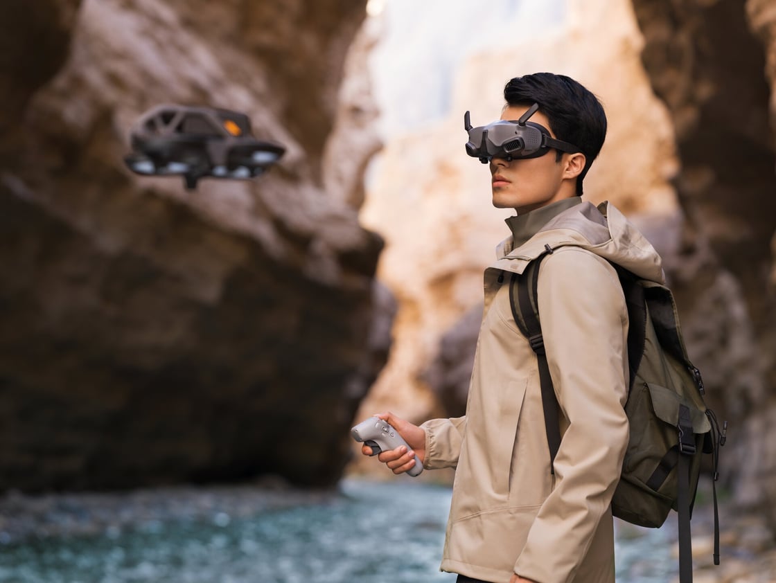 Un jeune homme pilote l'AVATA avec le motion controller et les DJI Goggles 2